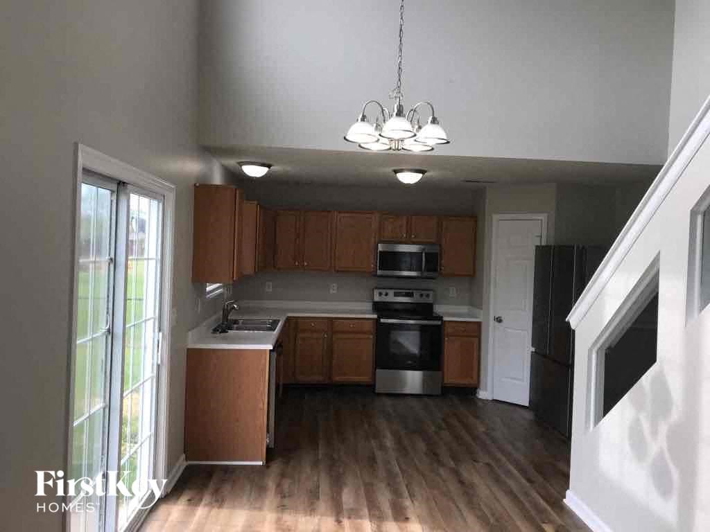 A kitchen with wooden cabinets and a stainless steel refrigerator.