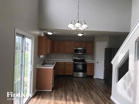 A kitchen with wooden cabinets and a stainless steel refrigerator.