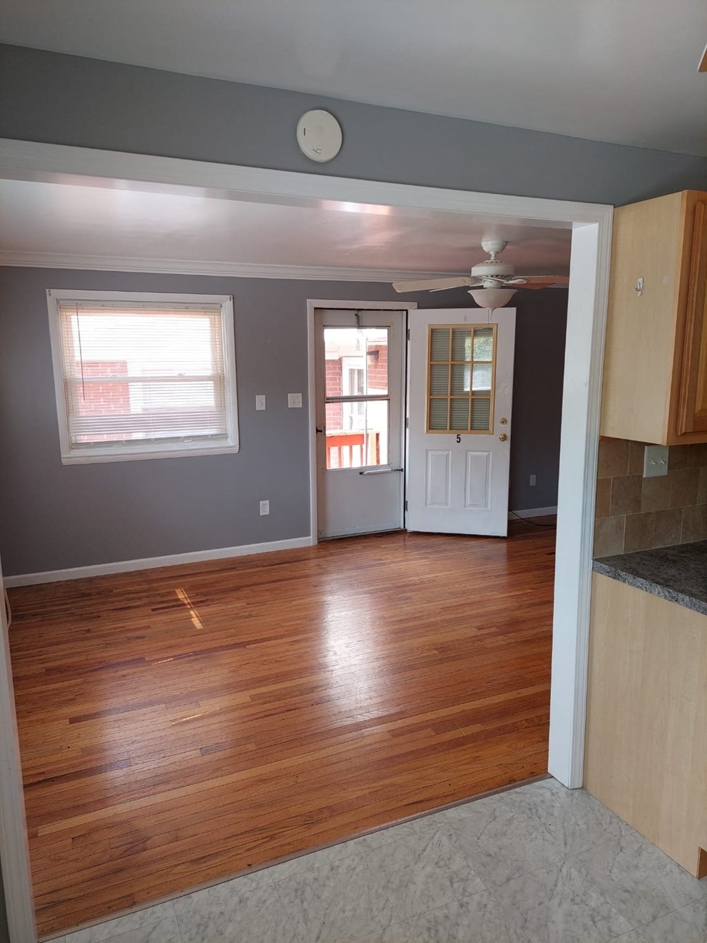 an empty living room with wood floors and a white door