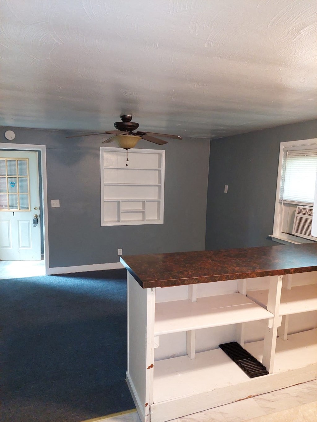 a kitchen with a counter top and a ceiling fan