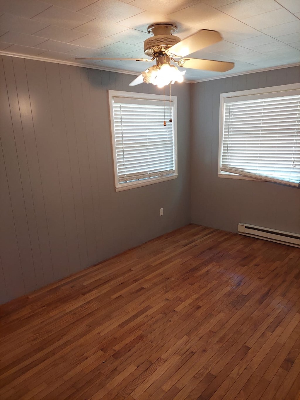 a living room with a wood floor and a ceiling fan