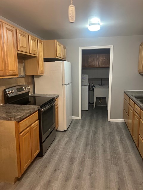 A kitchen with wooden cabinets and a black stove top oven.