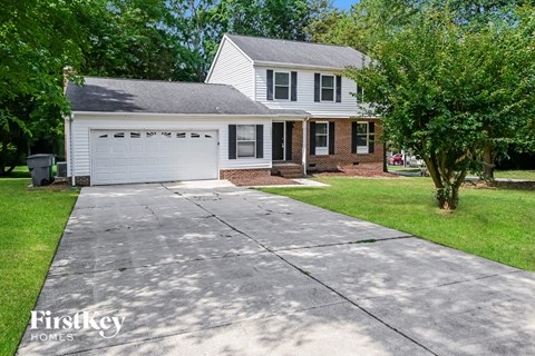 A house with a garage and a driveway in front of it.