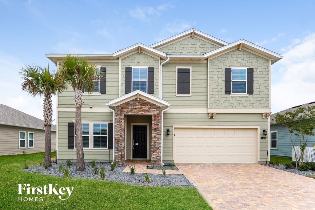 a house with a garage door and a palm tree