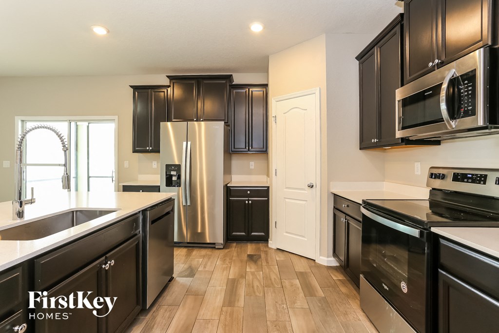 a kitchen with black cabinets and stainless steel appliances