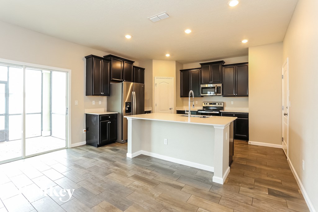 a kitchen with black cabinets and a large white counter top