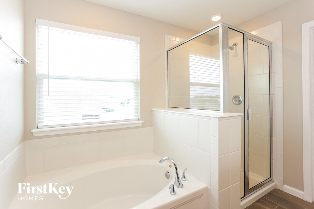 a bathroom with a tub and a shower and a window