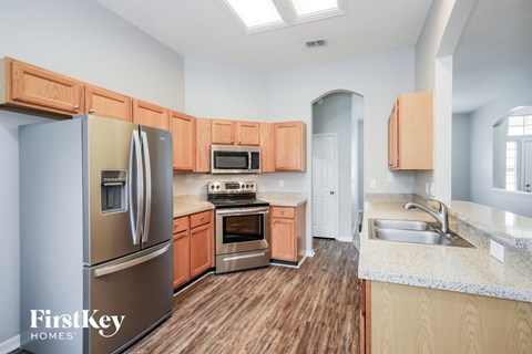 A kitchen with wooden cabinets and a stainless steel refrigerator.