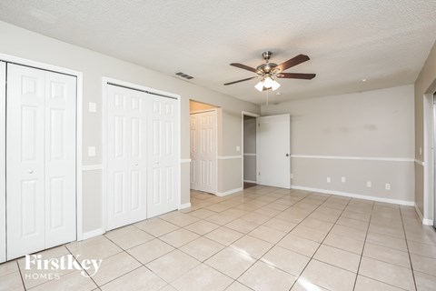 a living room with a ceiling fan and a tiled floor