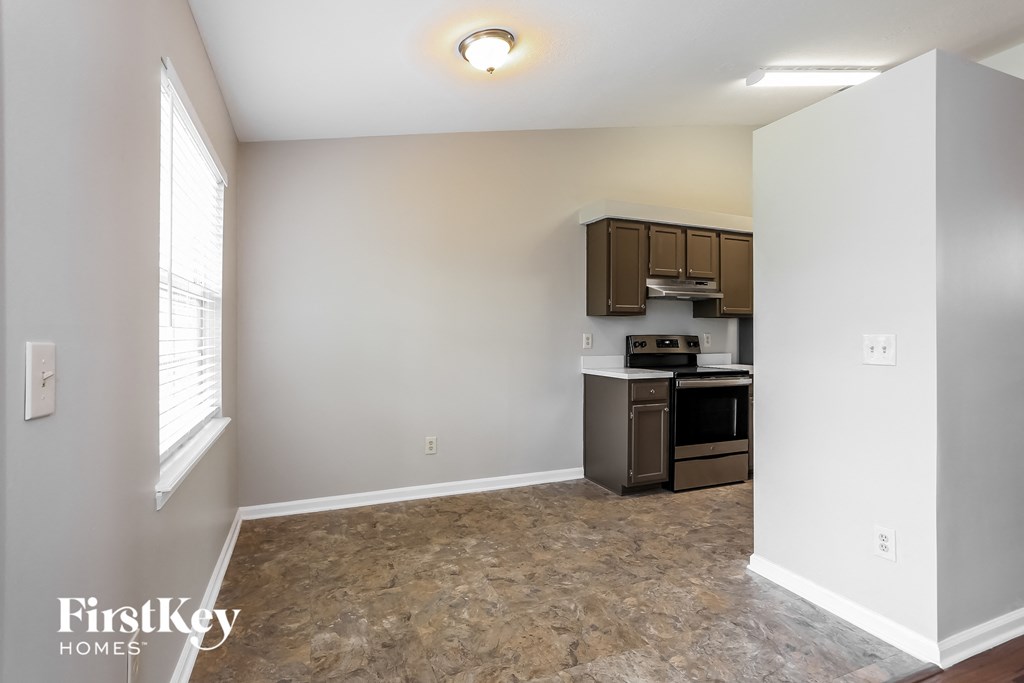 a kitchen with a stove and a sink and a window