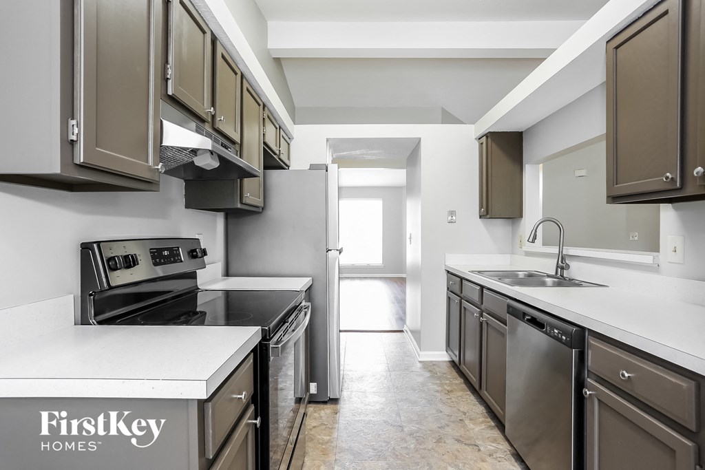 an empty kitchen with stainless steel appliances and white counter tops