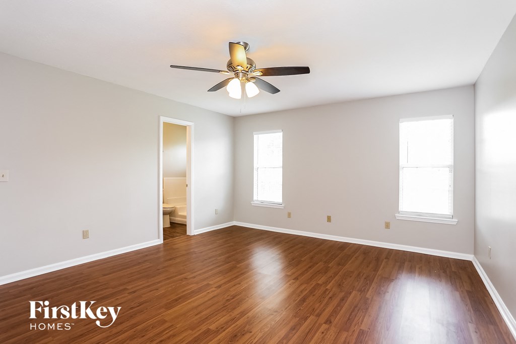 a living room with wood floors and a ceiling fan