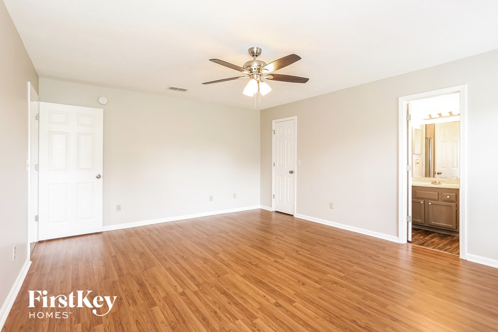 a living room with wood floors and a ceiling fan