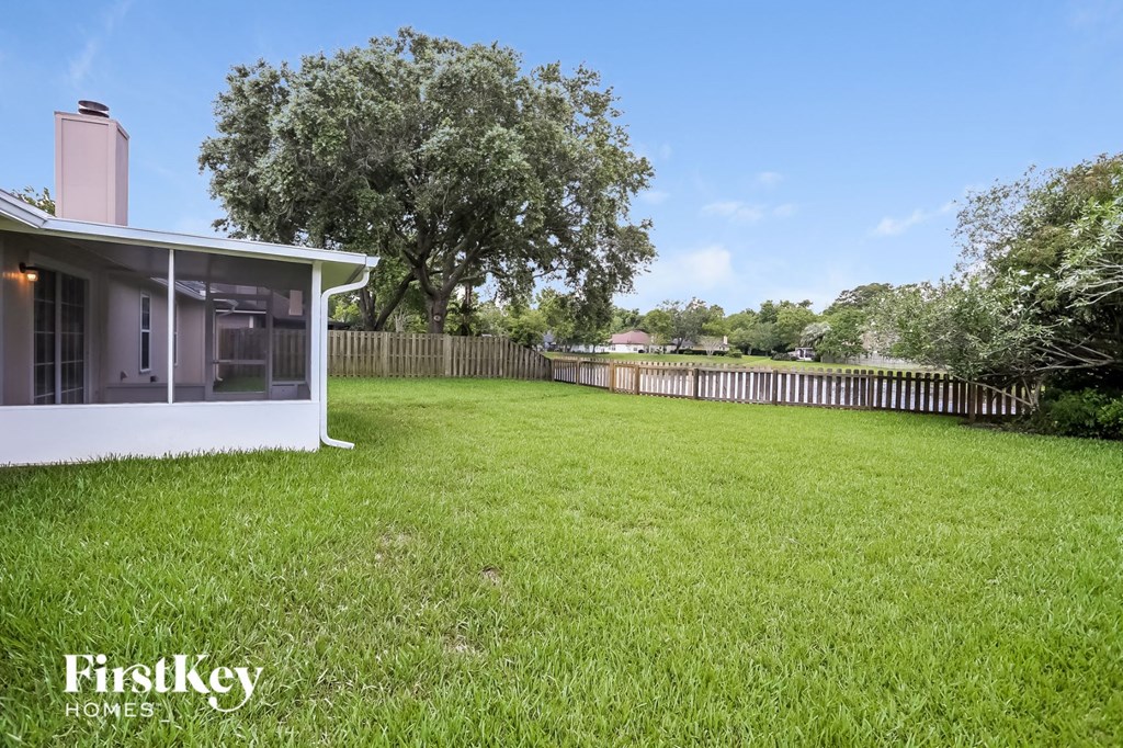 a backyard with a yard and a house with a fence