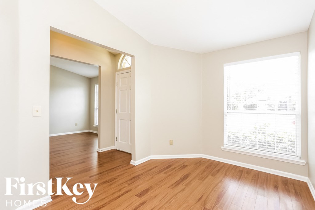 a living room with wood floors and a large window