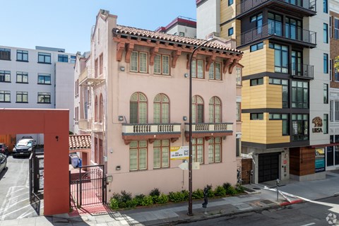 a pink building on the corner of a city street