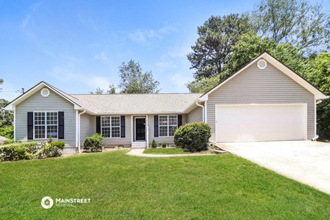 a blue house with a lawn and a garage door