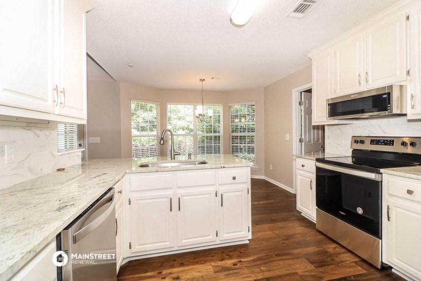 a kitchen with white cabinets and stainless steel appliances