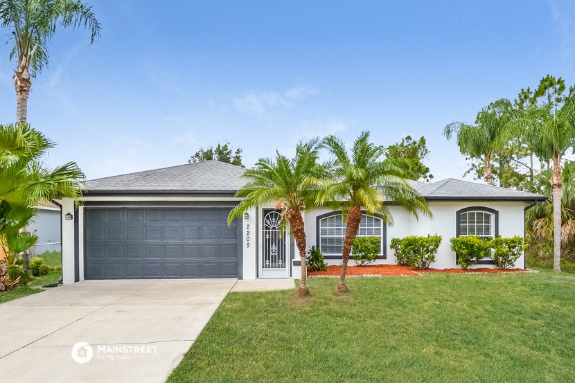 a white house with palm trees in front of it