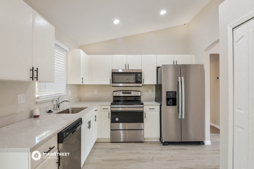 a modern kitchen with stainless steel appliances and white cabinets
