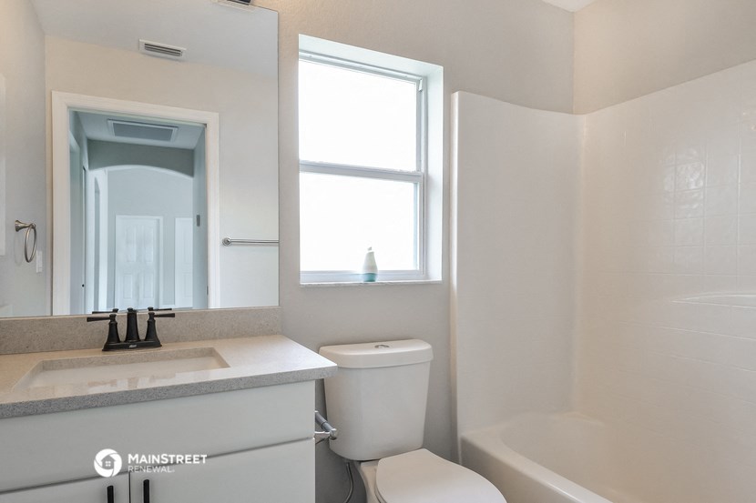 a bathroom with a toilet and a sink and a mirror