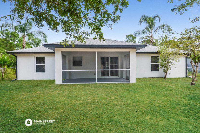 a white house with a lawn and a tree