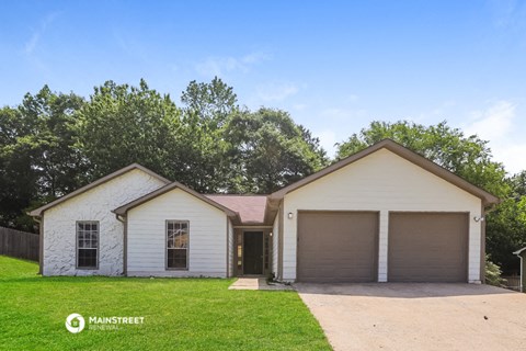 a white house with two garages and a lawn
