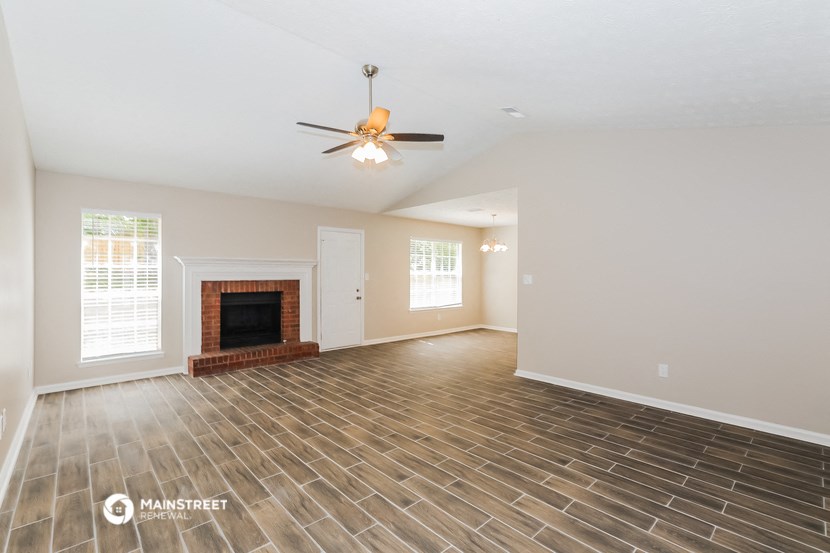 the living room with wood floors and a fireplace