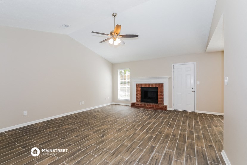 the living room with wood flooring and a fireplace
