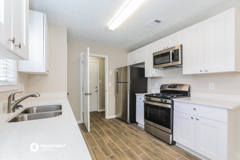 a kitchen with white cabinets and stainless steel appliances