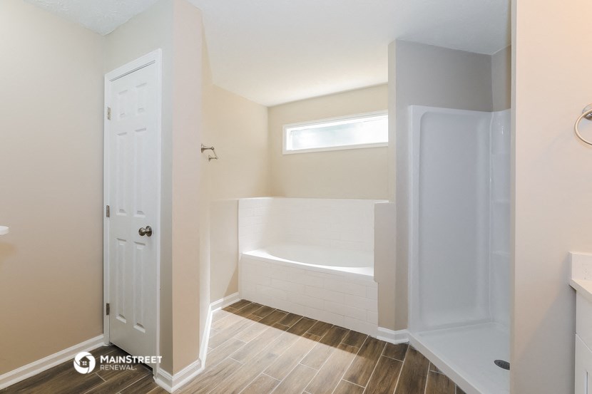 a bathroom with a tub and a white door