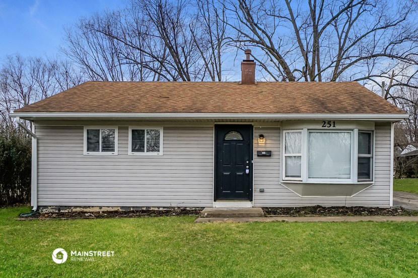 the front of a white house with a black door