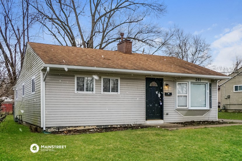 the front of a white house with a blue door