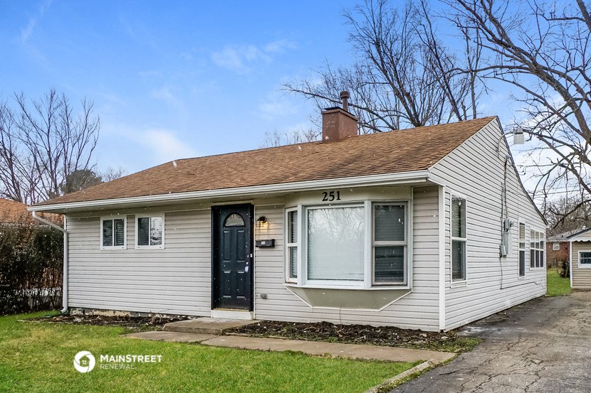 the front of a white house with a blue door
