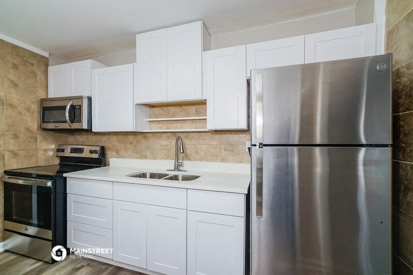 a kitchen with stainless steel appliances and white cabinets