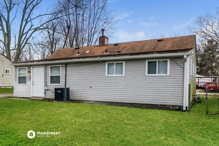 a small white house with a yard in front of it