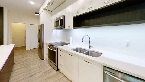 a kitchen with white cabinets and a sink and a microwave