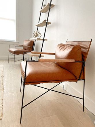 a pair of brown leather chairs in a room