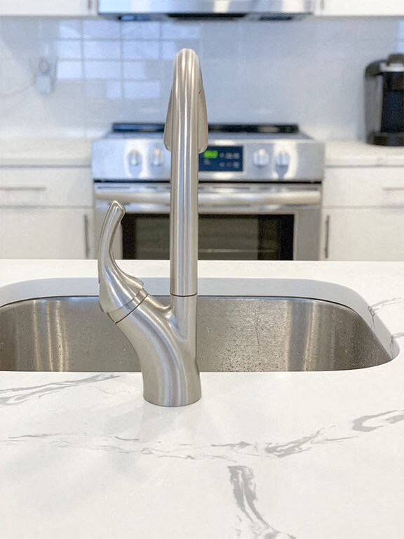 a kitchen sink with a stainless steel faucet