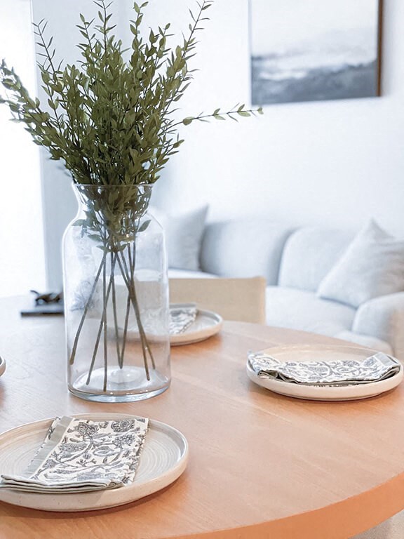a table with plates and a vase with flowers on it