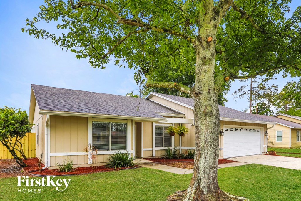 a yellow house with a tree in the front