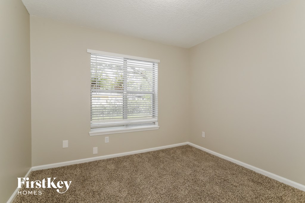 a empty room with carpet and a window