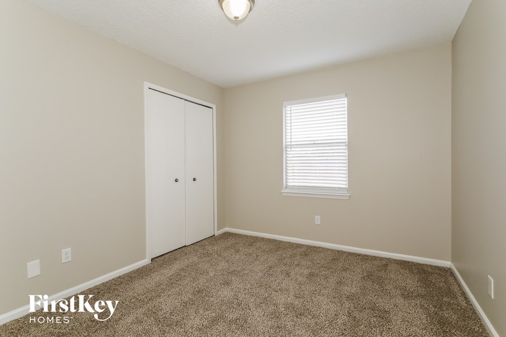 a bedroom with a carpeted floor and a closet