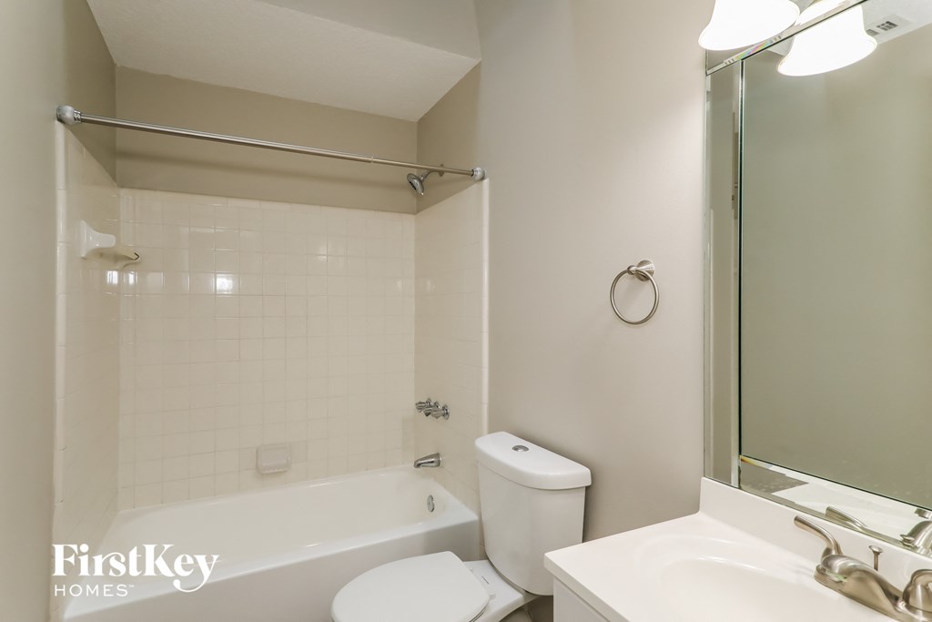 a white bathroom with a tub and a sink and a toilet