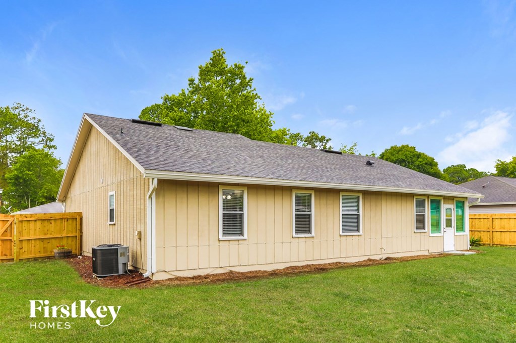 the front view of a yellow house with green shutters