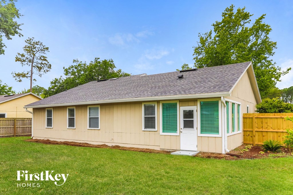 the front of a yellow house with green shutters