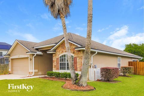 a home with two palm trees in front of it