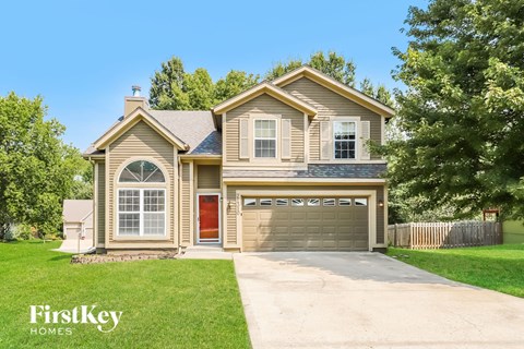 A house with a red door and a garage is shown.