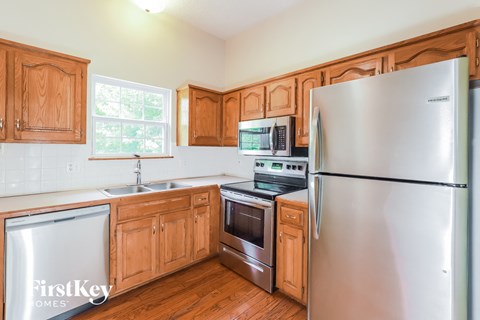 A kitchen with wooden cabinets and a stainless steel refrigerator.