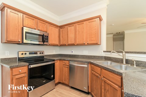 A kitchen with wooden cabinets and a stainless steel dishwasher.